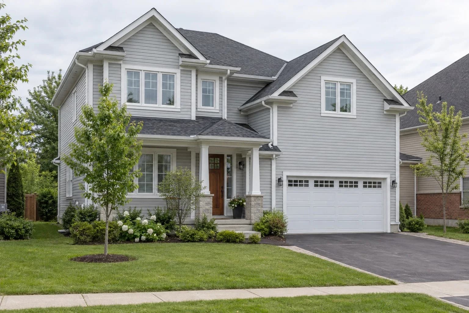 A two-storey Ontario house with light grey vinyl siding