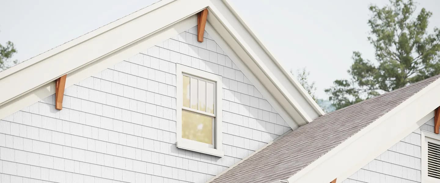 Pale grey Hardie Shingle straight edge panels on a craftsman gable with white trim, wood brackets and a double-hung window