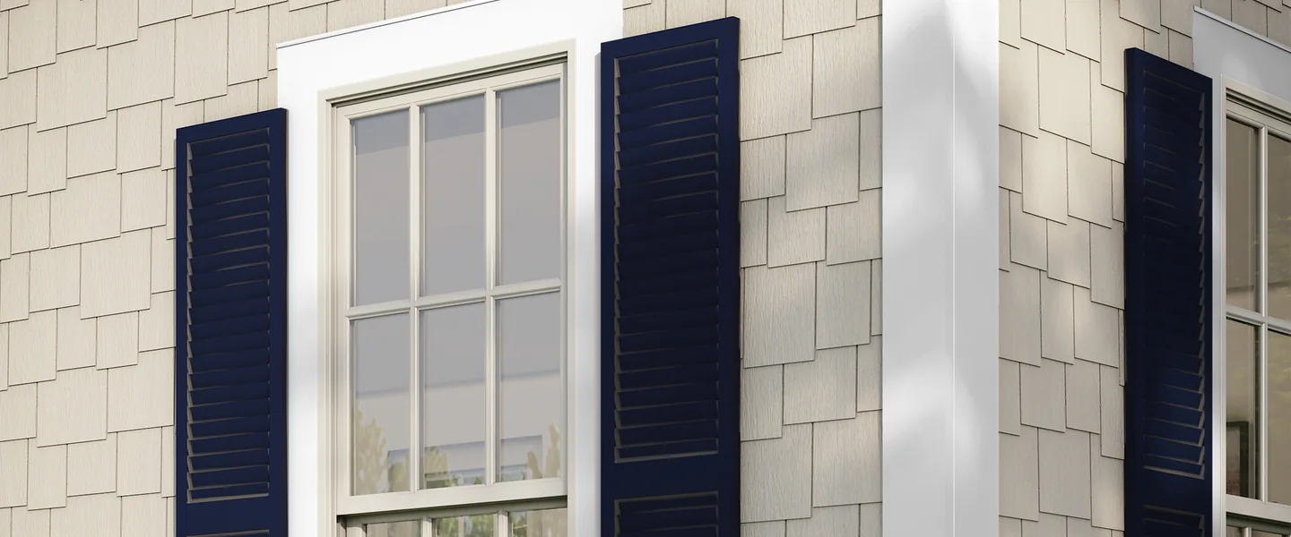 White Hardie Trim boards around a double-hung window and up the outside corner of a shingle-sided wall, with navy shutters