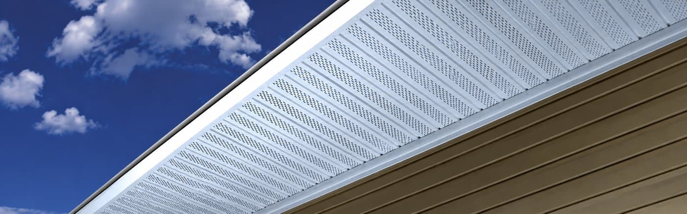 Kaycan Vinyl Soffit installed under home eave — white vented soffit against blue sky